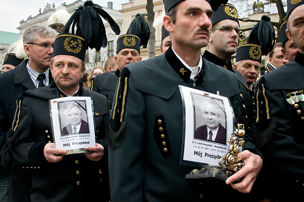Miners came from the southern Poland wait in a queue to the Presidential Palace to place a note in a book of condolence and pay a tribute to the dead President.
