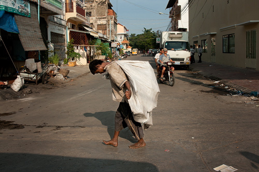 A recyclable waste collector walks in the center of Phnom Penh. Waste collectors are the poorest people in Cambodia and this job is their only way to gain any income.