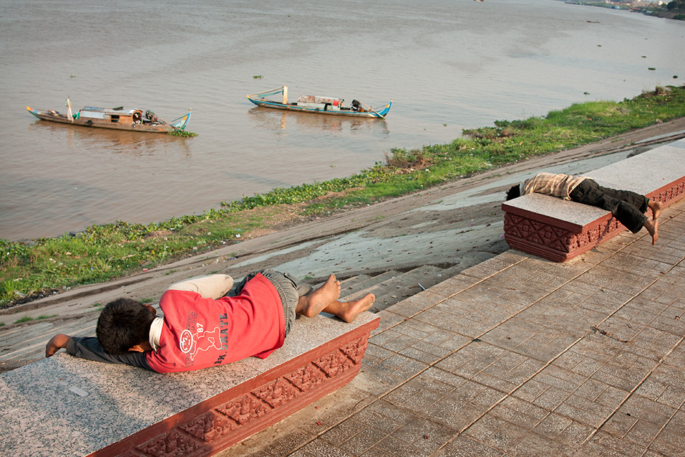 Young collectors take a nap on the riverside promenade in Phnom Penh. They scavenge the streets for useful material since early morning till very late every day.