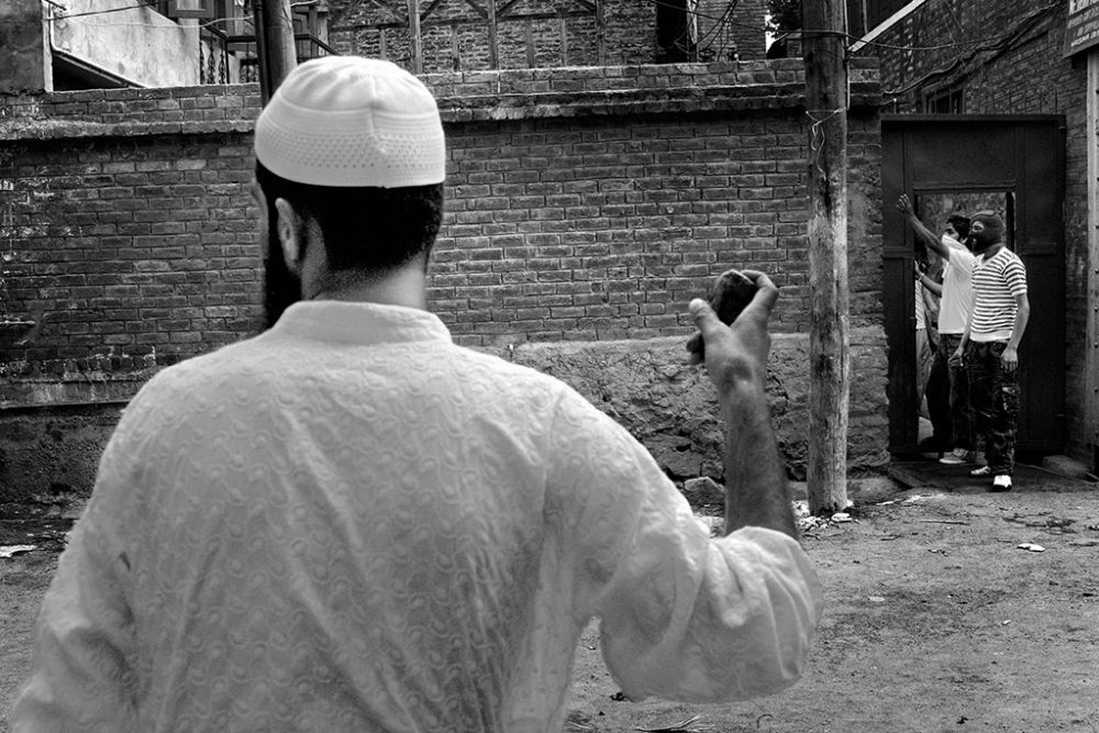 Local youths throw stones at the police. The riots started after two girls were found raped and murdered. The local community accuse Kashmiri police forces of this crime.