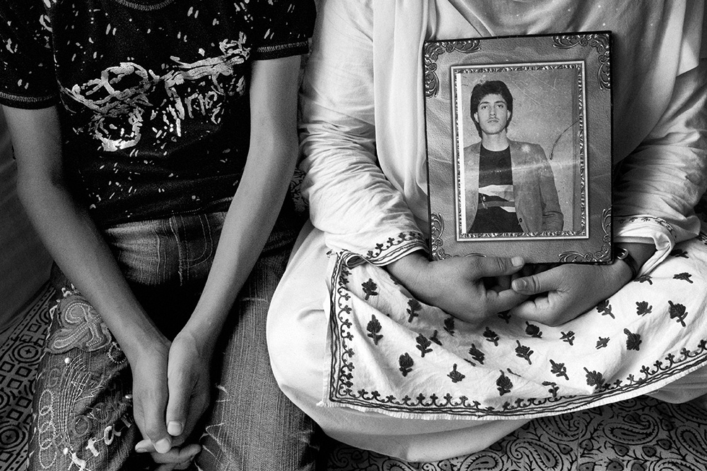 A woman with her son presents a portrait of her husband who is missing for several years.